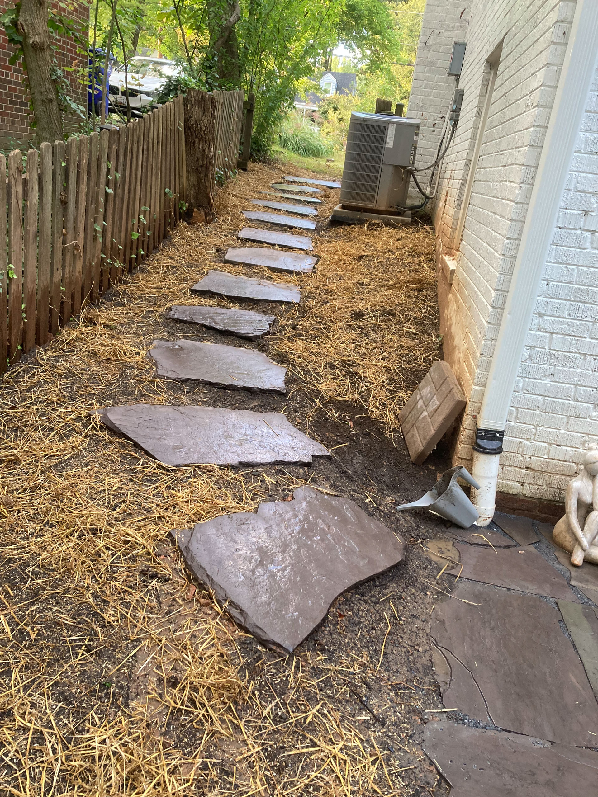 End result of a flagstone walkway built in Kensington, MD. Angle shows walkway meeting backyard patio.